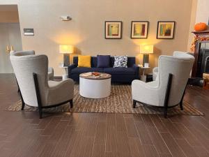 Comfort Suites Louisville Airport في لويزفيل: غرفة معيشة مع أريكة وكرسيين