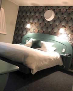 塞讷塞迪容旺火酒店的卧室里有一张大床，床头板是绿色的