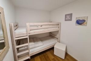 ein weißes Etagenbett in einem Zimmer in der Unterkunft Haus Allod 205 in Lenzerheide