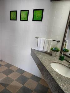 a bathroom with a sink and towels on a wall at Jazz Rainbow Paradise beachfront Peanag in Tanjung Bungah