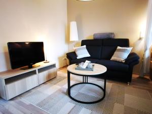 a living room with a black couch and a table at City Apartment Aurich - Ostfriesland in Aurich