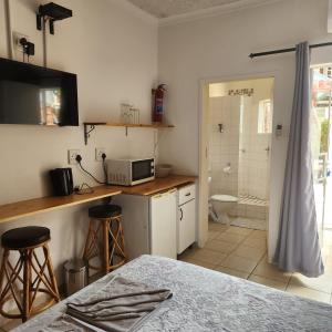 a kitchen with a counter with a microwave and a bathroom at Xaviera Guest House in Pretoria