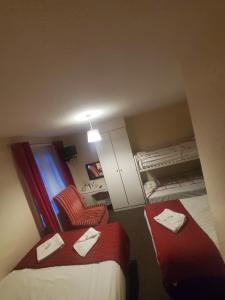 Habitación de hotel con 2 camas con sábanas rojas y silla en The Melville Hotel - Central Location, en Blackpool