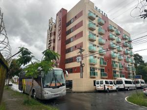 um autocarro está estacionado em frente a um edifício em LUXOR VEROLME HOTEL em Angra dos Reis