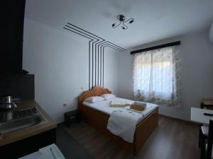 a small bedroom with a bed and a window at Elti Apartment in Sarandë