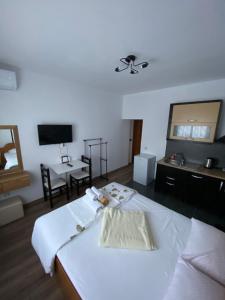 a room with a bed and a desk and a television at Elti Apartment in Sarandë