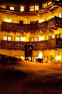 two people standing in front of a building at night at Hotel Saliter Hof in Saalfelden am Steinernen Meer