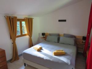 サルラ・ラ・カネダにあるPetit chalet cosy Sarlatのベッドルーム1室(黄色いタオル2枚付)