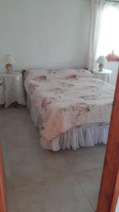 1 dormitorio con 1 cama con colcha de flores en Casa de campo en la Paloma, en Costa Azul