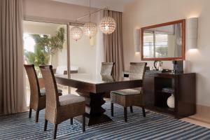 - une salle à manger avec une table, des chaises et un miroir dans l'établissement Jaz Crystal, Almaza Bay, à Marsa Matruh