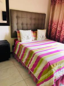 馬蓋特的住宿－Margate Accomodation，一间卧室配有一张大床和色彩缤纷的毯子