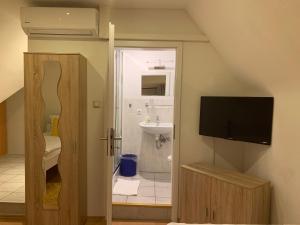 a bathroom with a television and a bathroom with a sink at Restaurant & Pension Peking in Diepholz +33 photos