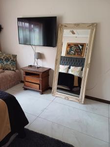 um quarto com um espelho, uma mesa e um sofá em Margate Accomodation em Margate