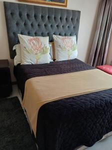 um quarto com uma cama grande e uma grande cabeceira. em Margate Accomodation em Margate