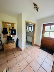een woonkamer met een deur en een tegelvloer bij Ferienwohnungen Britta Heim in Oberstaufen