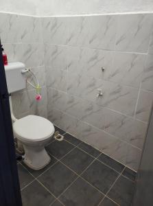 La salle de bains est pourvue de toilettes et d'un mur carrelé. dans l'établissement My Soul Homestay, à Kampong Ru Sepuloh