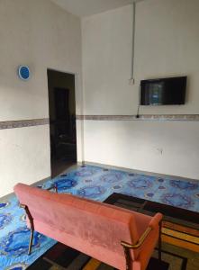 Cette chambre dispose d'un canapé et d'une télévision murale. dans l'établissement My Soul Homestay, à Kampong Ru Sepuloh