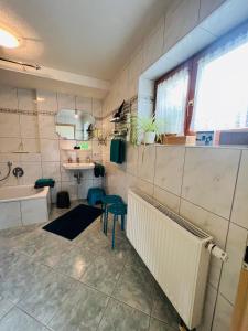 een badkamer met een radiator, een tafel en een wastafel bij Ferienwohnungen Britta Heim in Oberstaufen