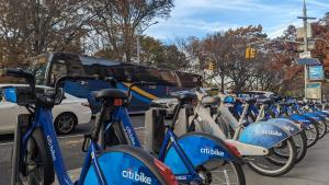 a row of blue bikes parked next to a bus at CENTRAL PARK EAST and MUSEUMS in New York