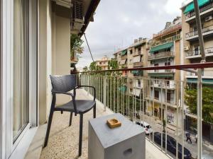 una silla en el balcón con vistas a la ciudad en KASO - Veikou, en Atenas