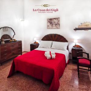 a bedroom with a large bed with a red blanket at La Casa dei Gigli in Lecce