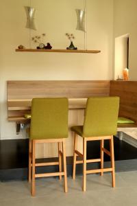 twee groene stoelen voor een bureau bij Ferienwohnung Kuschelecke in Michelstadt