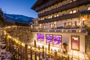 un edificio con luces de Navidad delante de él en Hotel Landhaus Zillertal, en Fügen