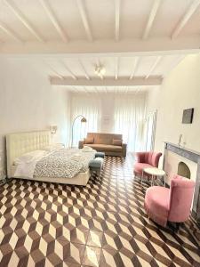 una camera con letto, divano e camino di Allegra Toscana - Affittacamere Guest house ad Arezzo