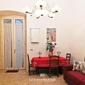 een woonkamer met een tafel met een rode tafelkleed bij La Casa dei Gigli in Lecce