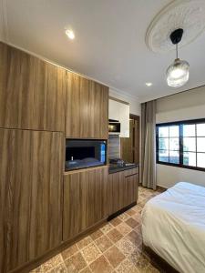 Un dormitorio con una cama y un televisor de pantalla plana. en 7/ Antica jabalal-lwebdeh, en Amán