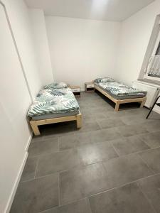 2 łóżka w pokoju z podłogą wyłożoną kafelkami w obiekcie B&B Immobilien GbR w mieście Xanten