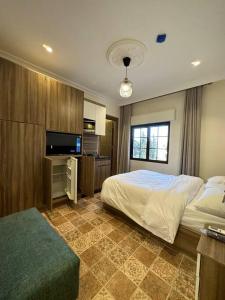Un dormitorio con una cama y un televisor de pantalla plana. en 7/ Antica jabalal-lwebdeh, en Amán