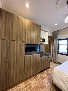 1 dormitorio con un gran armario de madera y TV en 7/ Antica jabalal-lwebdeh, en Amán