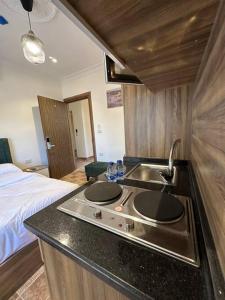 Una cocina con fregadero y una cama en una habitación. en 7/ Antica jabalal-lwebdeh, en Amán