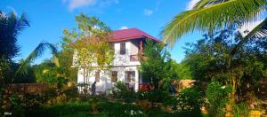 una casa bianca con tetto rosso e alberi di Villa de Flora Zanzibar 