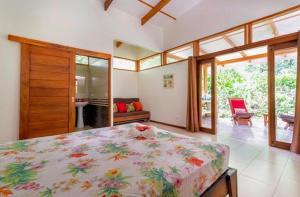 1 dormitorio con 1 cama grande en una habitación con ventanas en Peace Garden Spacious Bungalows- a walk to the beach, en Cocles