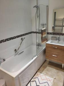 a bathroom with a shower and a tub and a sink at Aquavista Penthouse in Wyke Regis