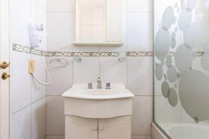 a white bathroom with a sink and a shower at Simplemente Mendoza ! Unica ! in Godoy Cruz