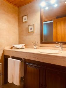 y baño con lavabo, espejo y toallas. en Casa Martagón - kasasbenas, en Benasque