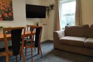a living room with a dining room table and a couch at Oliver Wests Beautiful 2 Bedroom Sleeps 4 Apartment in Scarborough