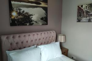 ein Schlafzimmer mit einem Bett und einem Bild an der Wand in der Unterkunft Oliver Wests Beautiful 2 Bedroom Sleeps 4 Apartment in Scarborough