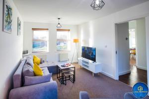 a living room with a couch and a tv at 3Bed House in Reading by Cabralproperties - free parking, Netflix and accommodate up to 7 people in Reading