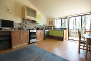 a large kitchen with wooden cabinets and a large window at Swifts Retreat in Buxton