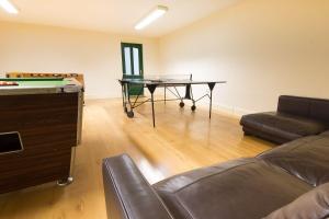 a living room with a ping pong table and a couch at Swifts Retreat in Buxton