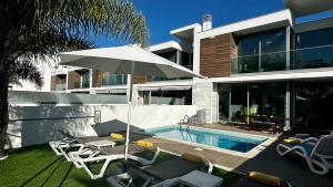 una casa con piscina y sombrilla en Moon by Check-in Portugal, en Albufeira