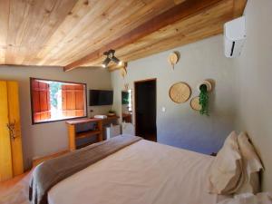 Un dormitorio con una cama grande y una ventana en Salto Corumbá Hotel Camping Clube, en Corumbá de Goiás