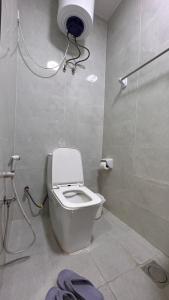 a bathroom with a white toilet and a shower at Basil Hostel in Muscat