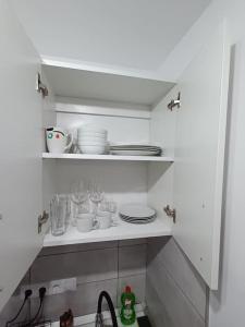 a kitchen with a shelf with dishes on it at Old Town Studio 2 Apartment nr 4 in Baia Mare