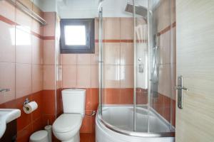 a bathroom with a toilet and a glass shower at Ageras Santa Marina in Lefkada