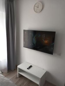 a living room with a white table and a clock on a wall at Old Town Studio 2 Apartment nr 4 in Baia Mare